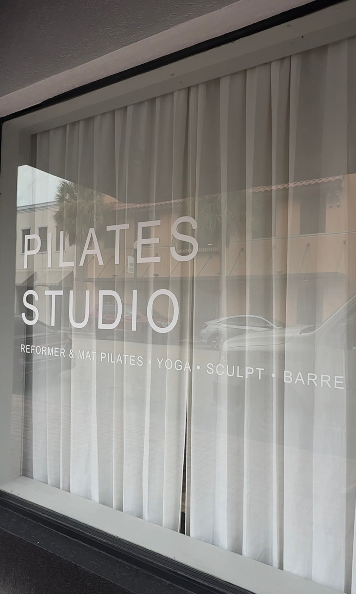 MindFlow Pilates Studio storefront window with Reformer & Mat Pilates, Yoga, Sculpt, Barre lettering